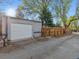 A detached one car garage and wood fence can be found at the end of the driveway at 386 Colorado Blvd, Denver, CO 80206