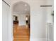 Hallway features a decorative archway, hardwood floors, and modern lighting at 386 Colorado Blvd, Denver, CO 80206
