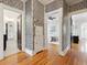 Hallway with patterned wallpaper, wood floors, and views of the bathroom and bedroom at 386 Colorado Blvd, Denver, CO 80206