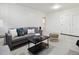 Bright living room featuring a gray sofa, neutral carpeting, and white paneled walls, creating a cozy and stylish space at 386 Colorado Blvd, Denver, CO 80206