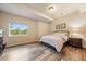 This bedroom features hardwood floors, a bed, and a large window offering views of the green landscape at 7829 S Coolidge Way, Aurora, CO 80016