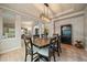 Stylish dining area with a modern light fixture, hardwood floors, and a view into the living area at 7829 S Coolidge Way, Aurora, CO 80016