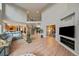 Open-concept living room boasts high ceilings, hardwood floors, and a large entertainment center at 7829 S Coolidge Way, Aurora, CO 80016