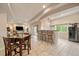 Open-plan living room featuring tiled flooring, a breakfast bar, and a dining table, creating an inviting space at 7829 S Coolidge Way, Aurora, CO 80016