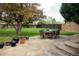 Outdoor stone patio with dining set, lush lawn, and mature trees, perfect for entertaining at 3811 E 26Th Avenue Pkwy, Denver, CO 80205
