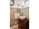 Charming half bath with vessel sink, unique brick accent wall, and bright blue mosaic tiling at 3811 E 26Th Avenue Pkwy, Denver, CO 80205