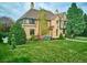 Beautifully landscaped lawn with mature trees surrounding an elegant brick home with a classic design at 3811 E 26Th Avenue Pkwy, Denver, CO 80205