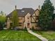 Charming brick home with a well-manicured lawn, mature trees, and an inviting walkway leading to the front door at 3811 E 26Th Avenue Pkwy, Denver, CO 80205