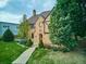 Lovely brick home with lush green lawn, mature trees, and a welcoming walkway leading to the front door at 3811 E 26Th Avenue Pkwy, Denver, CO 80205