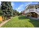 Spacious backyard with lush lawn, mature trees, and a charming covered patio, perfect for outdoor entertaining at 7629 S Fillmore Way, Centennial, CO 80122