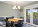 Cozy dining area featuring a round wood table with chandelier and natural light from the access to the covered porch at 7629 S Fillmore Way, Centennial, CO 80122