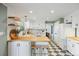 Charming kitchen with white cabinets, butcher block countertops, stainless appliances, and black and white tile floors at 7629 S Fillmore Way, Centennial, CO 80122