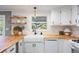 Updated kitchen featuring butcher block countertops, white cabinets, and a farmhouse sink, creating a warm, inviting space at 7629 S Fillmore Way, Centennial, CO 80122