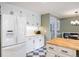 Bright kitchen with white cabinets, stainless refrigerator, butcher block countertop, and retro black and white floors at 7629 S Fillmore Way, Centennial, CO 80122