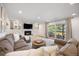 Inviting living room with a comfortable sectional sofa, built-in cabinets, a fireplace, and access to outdoor patio at 7629 S Fillmore Way, Centennial, CO 80122