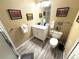 Modern bathroom with a gray wood-look floor, white vanity, and framed art at 227 Powderhorn Trl, Broomfield, CO 80020