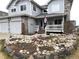 Inviting home with a charming rock garden, covered porch, and American flag at 227 Powderhorn Trl, Broomfield, CO 80020