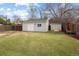 Large backyard showcasing a detached garage, green lawn, and mature trees along the fence line at 3244 S Holly St, Denver, CO 80222