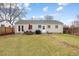 Expansive backyard view featuring a lush green lawn, detached garage, patio, and home's rear elevation at 3244 S Holly St, Denver, CO 80222