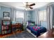 Bright bedroom with blue walls, hardwood floors, and desk at 3244 S Holly St, Denver, CO 80222