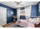 bedroom with navy walls, hardwood floors, and white curtains at 3244 S Holly St, Denver, CO 80222