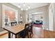 An open dining room with hardwood floors, a wooden table, and a view into the living room with blue couch at 1939 W 39Th Ave, Denver, CO 80211