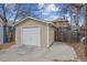 Exterior view of a detached one-car garage with white door and tan siding and driveway at 1939 W 39Th Ave, Denver, CO 80211