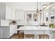 Bright kitchen featuring white cabinets, a breakfast bar, pendant lighting, and stainless steel appliances at 1939 W 39Th Ave, Denver, CO 80211