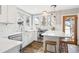 Well-lit kitchen with stainless steel appliances, tile floors, white cabinets, and a butcher block breakfast bar at 1939 W 39Th Ave, Denver, CO 80211