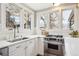 Modern kitchen featuring stainless steel appliances, white cabinets, and bright lighting from multi-paned windows at 1939 W 39Th Ave, Denver, CO 80211