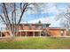 Back exterior view of brick home with deck, stairs, and spacious yard at 5862 Owens St, Arvada, CO 80004