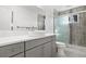 Modern bathroom with gray cabinets, double vanity, and a sliding glass shower door at 5862 Owens St, Arvada, CO 80004