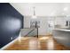 Bright dining room with hardwood floors, a modern light fixture, and adjacent open kitchen at 5862 Owens St, Arvada, CO 80004