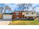 Two-story brick home featuring a two-car garage and a well-maintained lawn at 5862 Owens St, Arvada, CO 80004