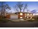 Two-story brick home featuring a two-car garage, beautiful lighting, and a well-maintained lawn at 5862 Owens St, Arvada, CO 80004