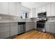 Well-lit kitchen featuring gray cabinets, modern appliances, and stylish backsplash details at 5862 Owens St, Arvada, CO 80004