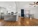 Open living space with hardwood floors connecting the kitchen and dining area with staircase at 5862 Owens St, Arvada, CO 80004