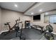 Finished basement with gym featuring padded floors, television, weight equipment, and exercise bike at 171 N Newbern Way, Aurora, CO 80018