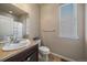 This bathroom features a single sink vanity with a neutral countertop and standard toilet next to a window at 171 N Newbern Way, Aurora, CO 80018