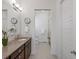 A stylish bathroom featuring a single sink, quartz countertops and and open entry to a tiled shower at 10258 W Coal Mine Pl, Littleton, CO 80127
