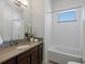 Cozy bathroom featuring a tiled bathtub, modern vanity with an integrated sink and quartz countertops at 10258 W Coal Mine Pl, Littleton, CO 80127