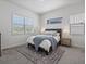 Bright bedroom featuring a comfortable bed with soft blue accents and natural light from two windows at 10258 W Coal Mine Pl, Littleton, CO 80127