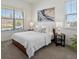 A bright bedroom featuring a large window, a comfortable bed and two bedside tables with lamps at 10258 W Coal Mine Pl, Littleton, CO 80127