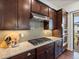 Modern kitchen featuring stainless steel appliances, gas range, dark cabinetry, and stylish backsplash at 10258 W Coal Mine Pl, Littleton, CO 80127