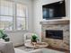Cozy living room featuring a brick fireplace, large screen television and a view out of the window at 10258 W Coal Mine Pl, Littleton, CO 80127