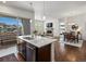 Inviting kitchen and living space with an island, stainless steel appliances, fireplace, and backyard view at 10258 W Coal Mine Pl, Littleton, CO 80127