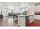 Open-concept living room with hardwood floors, modern kitchen island, and bright natural light at 11330 Pacific Peak Ct, Parker, CO 80134