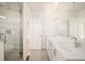 Modern bathroom featuring double sinks, white cabinets, and walk-in shower at 2685 S Acoma St, Denver, CO 80223