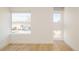 Bright bedroom featuring hardwood floors and two windows providing ample natural light and neighborhood views at 2685 S Acoma St, Denver, CO 80223