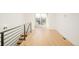 Open landing with modern metal railing and light hardwood floors, offering a bright transition between levels at 2685 S Acoma St, Denver, CO 80223
